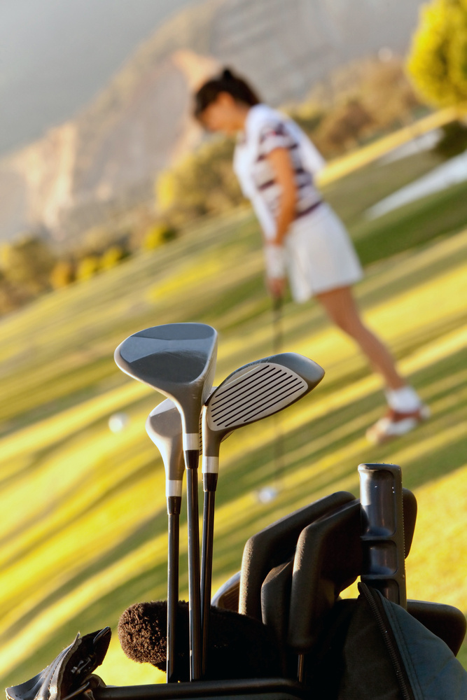 Bag of golf clubs outdoors and a player on the background Bag of golf clubs outdoors and a player on the background