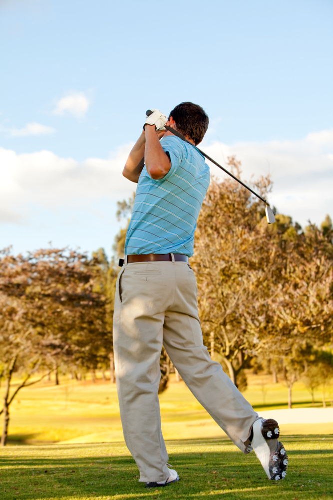 Full body young man outdoors playing golf hitting the bal Full body young man outdoors playing golf hitting the bal