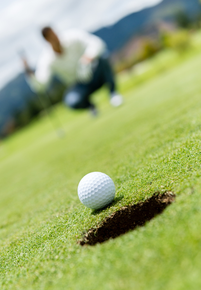 Golf ball very close to going into a hole Golf ball very close to going into a hole