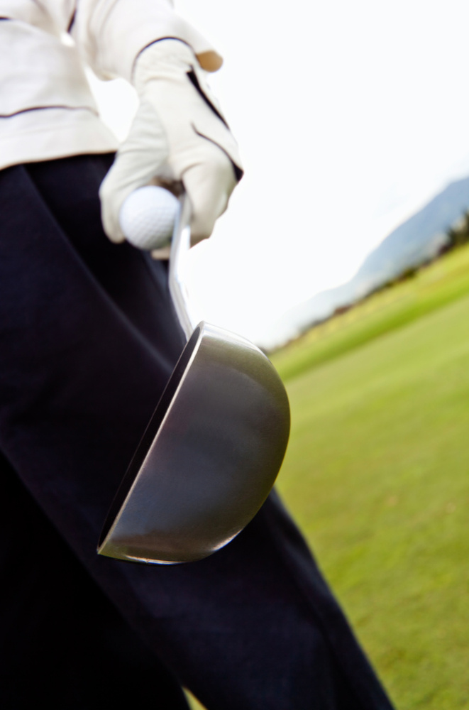 Golf player close-up on hand holding ball and club Golf player close-up on hand holding ball and club
