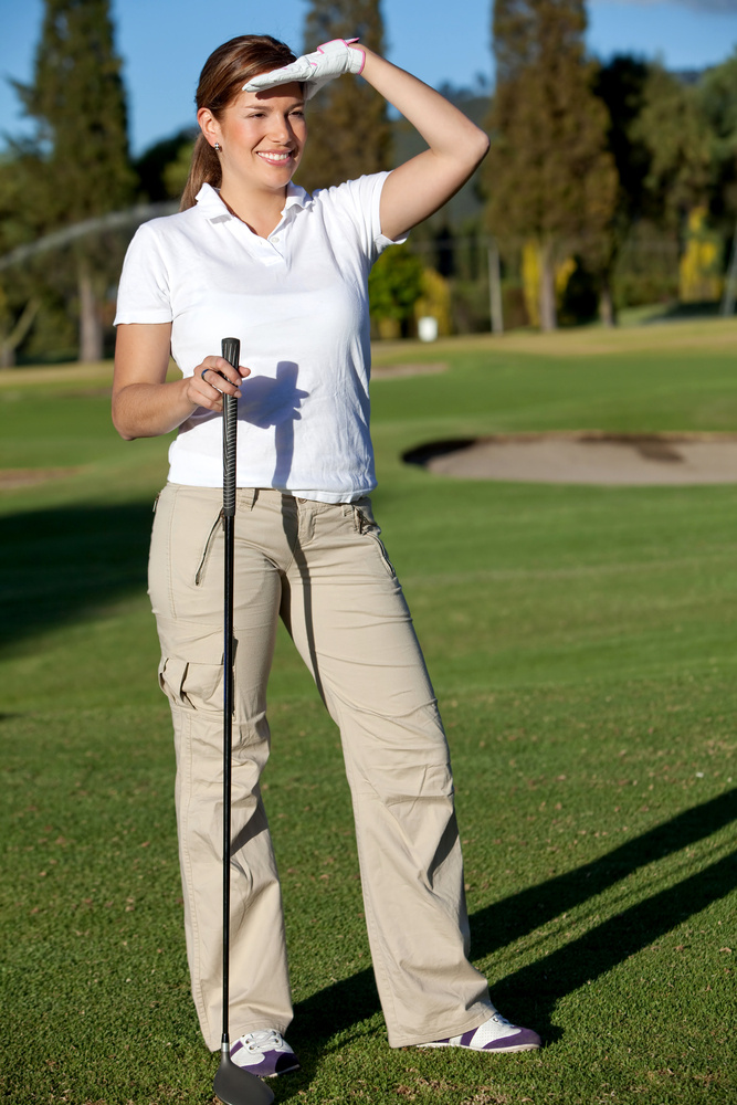 Young female player at a golf course smiling Young female player at a golf course smiling